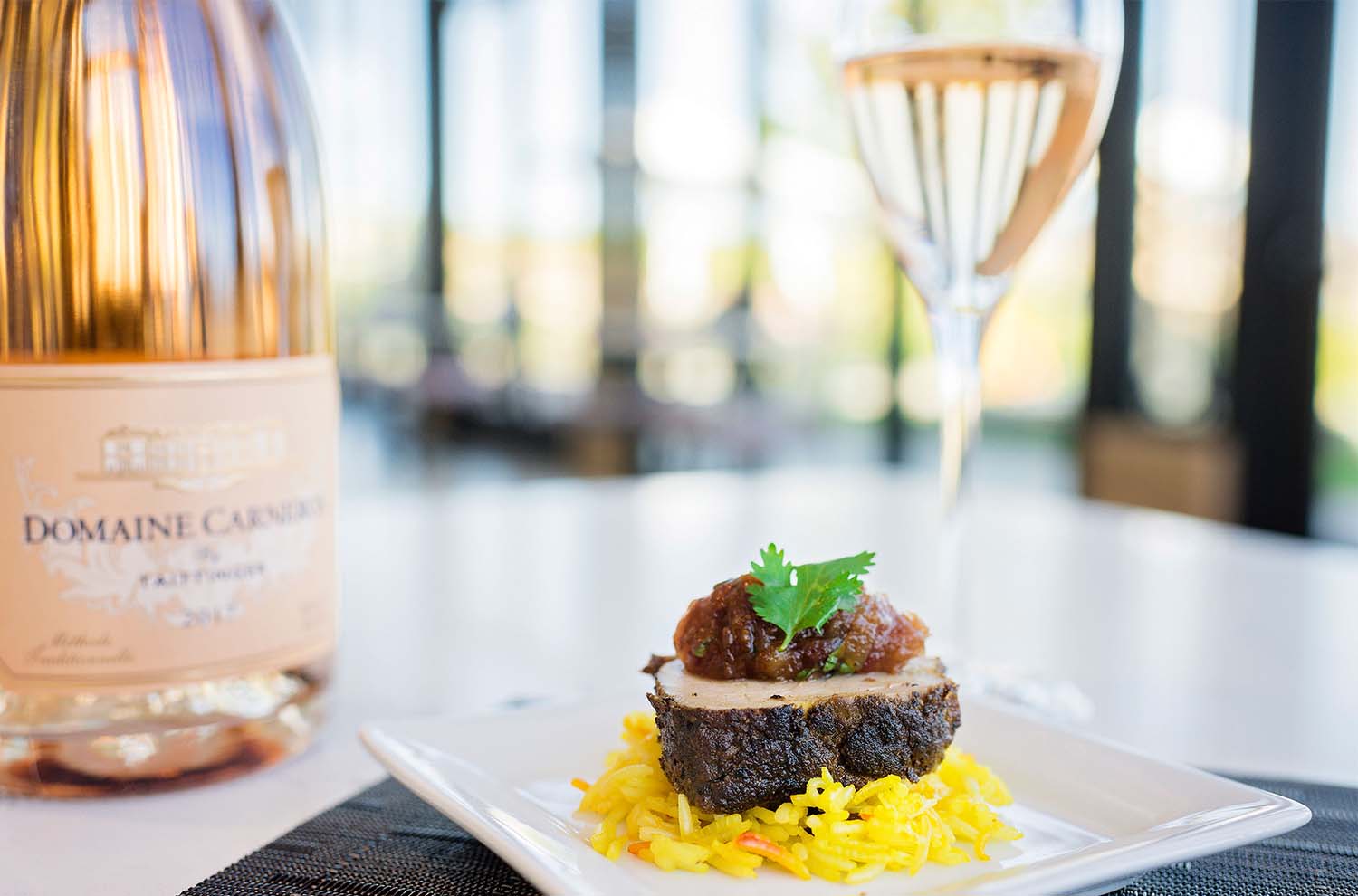 Moroccan Spiced Pork on rice with bottle of Rosé and glass