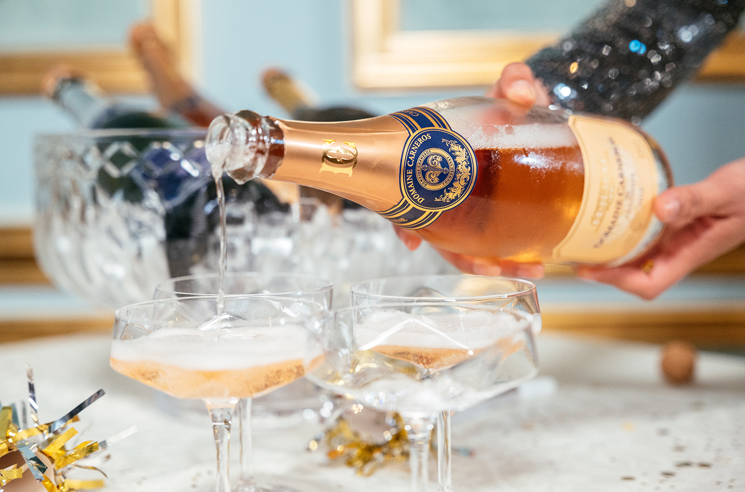 Bottle of sparkling rose poured into coupes.