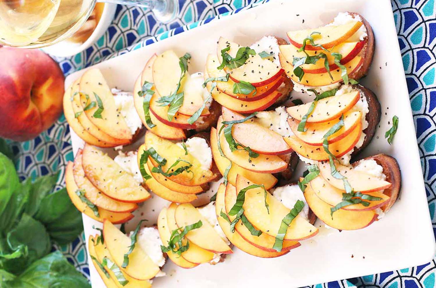 platter of peach ricotta crostini with basil