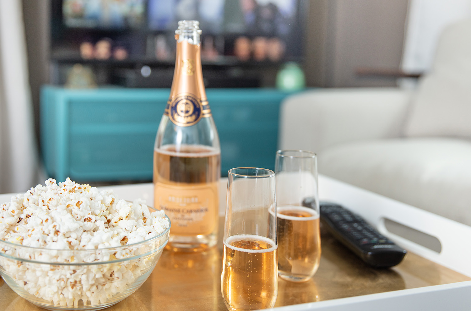 Bowl of popcorn with bottle of rose and flutes