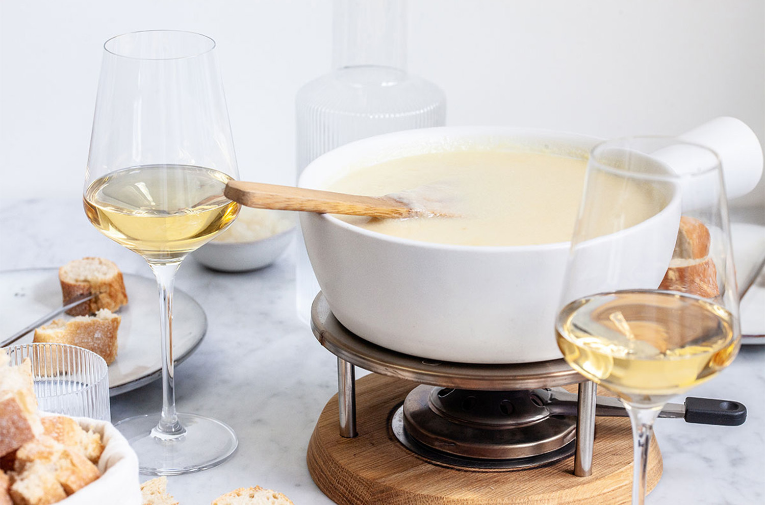 pot of fondue with two wine glasses